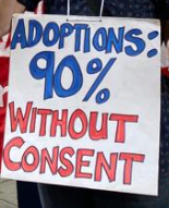 Photo of a placard which says Adoptions: 90% without consent.  In blue and red capital letters.