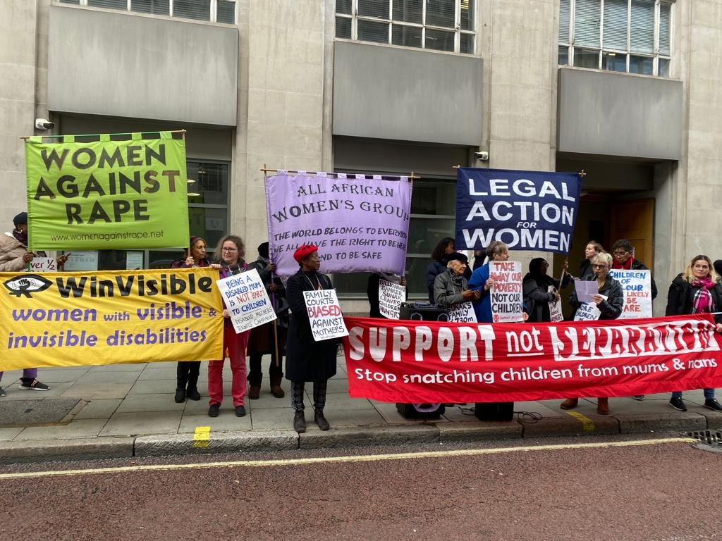 Diverse women holding banners and placards outside a large imposing building (Family Court). Women Against Rape green banner. WinVisible. All African Women's Group. Legal Action for Women. Support Not Separation -- Stop snatching children from mums & nans.