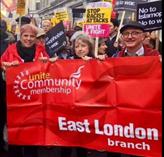 Women and a man holding the red Unite Community East London branch banner.  Behind them are placards -- No to Islamaphobia, No to war.  Stop racist attacks, unite and fight.