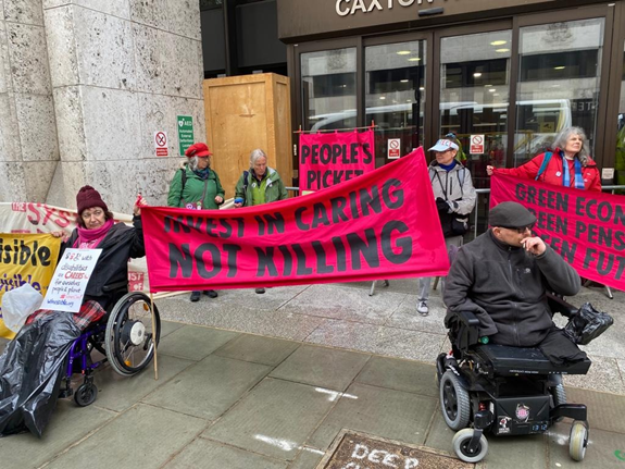 In front of Caxton House, holding XR dark pink banners with slogans in capitals: People's Picket.  Green economy, green pensions, green future.  Invest in caring not killing.