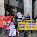 Protesters outside a large building. Women hold the WinVisible banner, next to people holding a red Unite Community Haringey & Barnet branch banner. Our placards say: "Hands off substantial risk to health, protection for claimants. Benefit cuts are killing us! DWP Deliberate Destitution of Kids and Mums is State cruelty. Remembered -- Elaine Morrall, single mum of 4, killed by UC sanction Nov 2017. " A policeman leans against the wall.