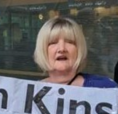 Photo of Micheleine Kane, a white woman with blonde hair. She is at a demonstration.
