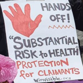 Placard with a big hand drawn with red pen.  Hands off "Substantial risk to health" protection for claimants.  WinVisible.org