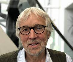 Photo of Prof Luke Clements. He has grey hair, a beard and glasses. He is smiling.