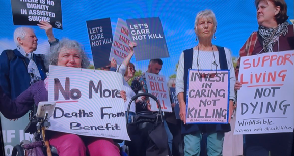 Women protesters against assisted dying, with other protesters behind.